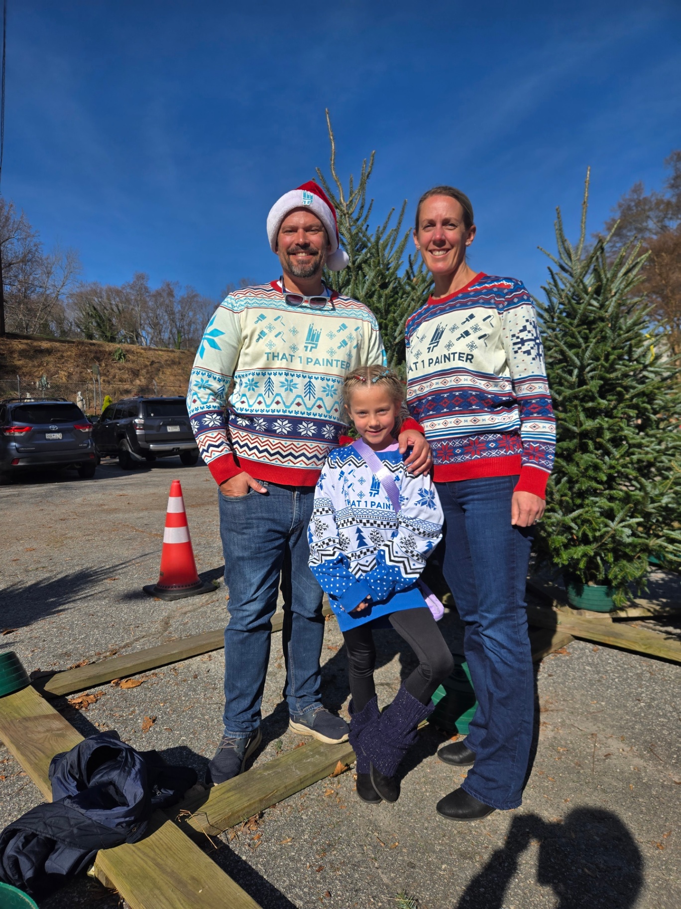 Geoff Petis with his family in That 1 Painter holiday sweaters at a tree lot.